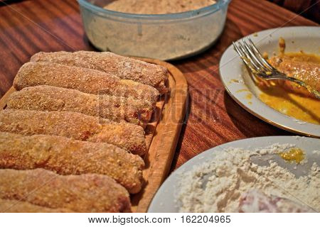 Making stuffed Karadjordje schnitzel on a wooden table