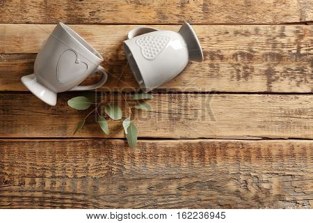 Two cups on wooden table, top view