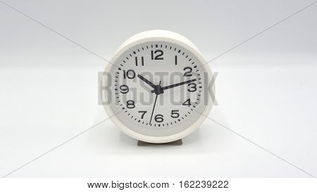White clock with minute hand and hour hand on white background.