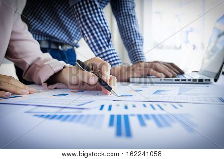 Team work process. young business managers crew working with new startup project. labtop on wood table typing keyboard texting message analyze graph plans