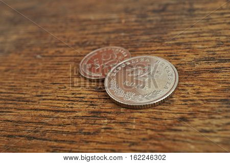 Macro detail of Croatian coins (Kuna and Lipa, HRK) on the wooden desk as a financial background of currency used in Croatia