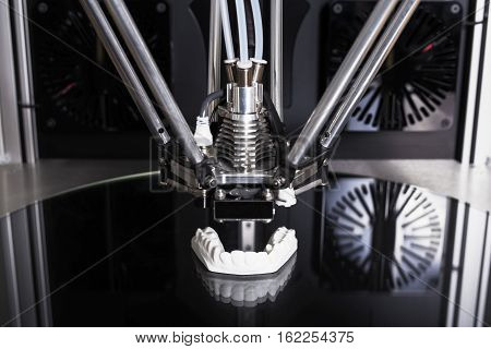 3D printer printing an object  on glass