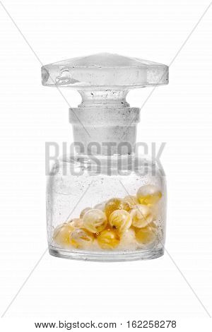 Old glass bottle filled with amber stones on a white background.