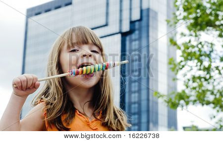 Niña disfrutando el día fuera de la ciudad comiendo dulces y diversión.