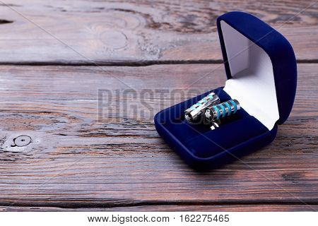 Cufflinks in velvet blue box. Case with cufflinks on wood. Formal stylish look accessory.