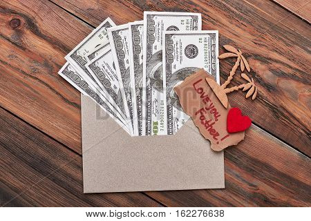 Palm and money in envelope. Love you father inscription. Memorable trip for daddy.