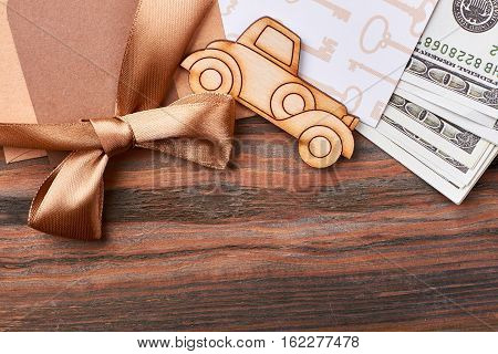 Money and ribbon bow. Pyrography car and blank paper. Posh and rich gift.