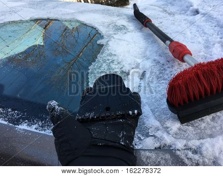 Winter driving tools for clearing car of snow and ice to avoid accident with person holding broken piece of ice scrapper and snow cleaning brush after polar vortex ice storm To avoid accident with copy space