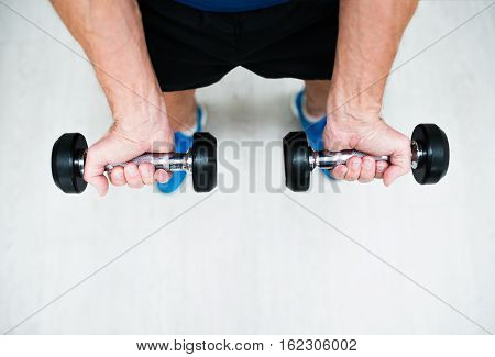 Close up of hands of senior man in gym working out with weights