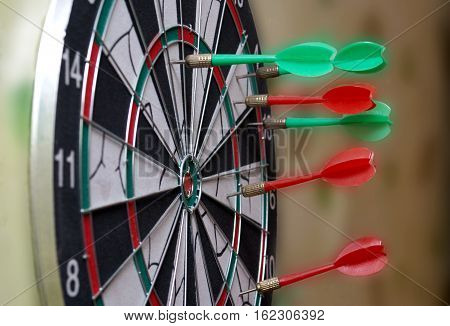 Red and green dart arrow hit the Board. Blurred background.
