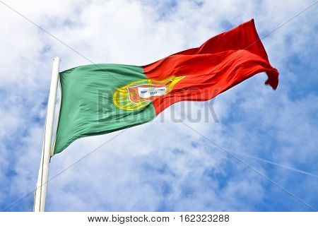 Portugal flag view from below waving against a blue sky