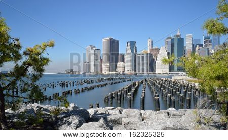 Old pier pylons and Downtown Manhattan New York City.