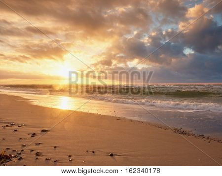 Beach Sand With Stones And Water Trails. Traces On Beach At Smooth Sea,