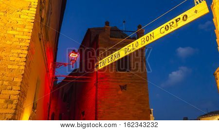 Night view of narrow alley with historic old houses in the medieval city of Castignano (Italy) during Templaria Festival
