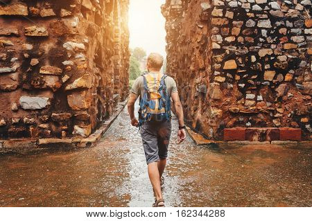 Tourist man walking by the Qutb Minar ruines streets