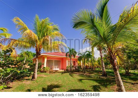 Cayo Coco island, Memories Carib hotel, June 30, 2016, amazing beautiful, gorgeous view of resort bungalow house standing in tropical garden against blue sky background on sunny day