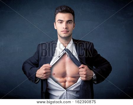 Businessman tearing off his shirt and showing mucular body concept on background