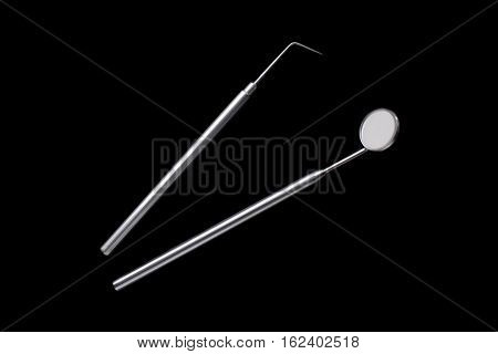 Dental mirror and dental sonde. Image isolated on black background.