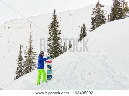 Freerider Man Is Standing On The Mountainside In A Helmet And With A Backpack And Looks Into The Dis