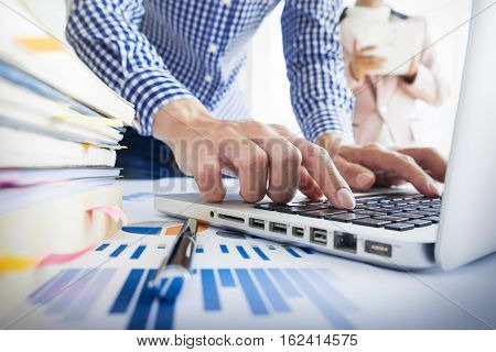 Team work process. young business managers crew working with new startup project. labtop on wood table typing keyboard texting message analyze graph plans