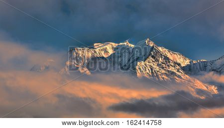 Mont Blanc above the clouds in winter at the sunset.