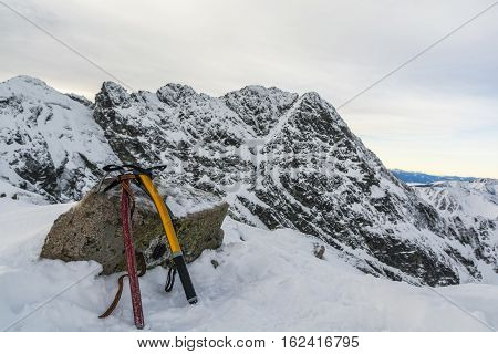 Two ice axes on the peak of the ridge in the background.