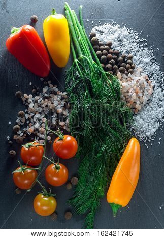 vegetables and spices on a black background, dill and pepper salt