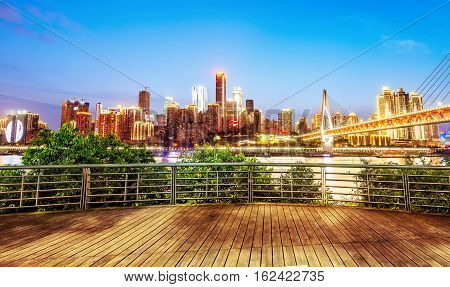 cityscape and skyline of downtown near water of chongqing at night