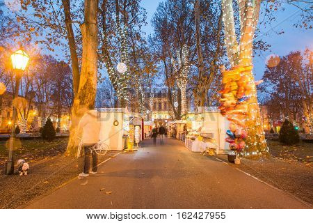 Advent time in the center of Zagreb, Croatia, people gathering in Zrinjevac park with food stands, blurred motion, unrecognizable people