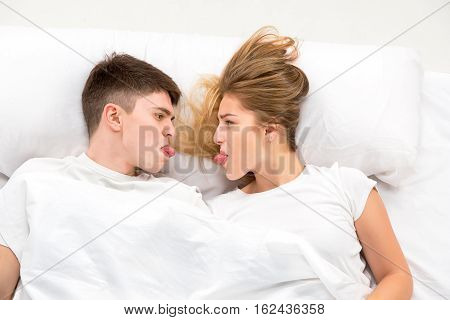 The young lovely couple lying in a white bed, love lconcept, top view