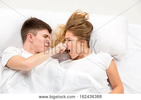 The young lovely couple lying in a white bed, love lconcept, top view
