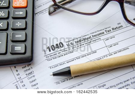 Individual income tax return form glasses pen and calculator