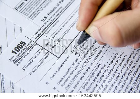 Person completing 1065 tax form. business concept