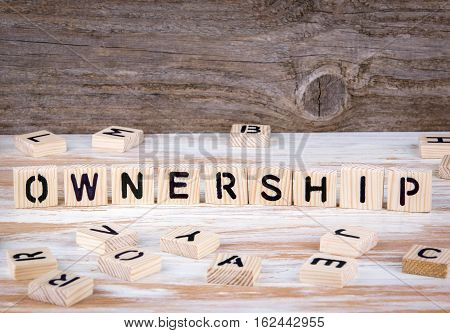 Ownership from wooden letters on wooden background