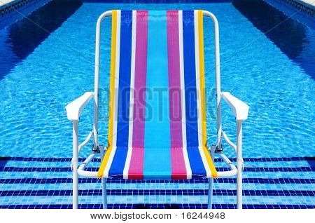 una sedia a sdraio in piscina in estate