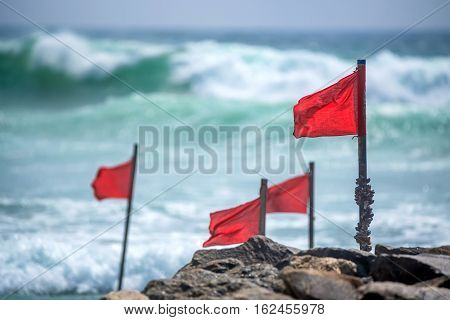 Red warning flag on beach showing that swimming is dangerous or prohibited
