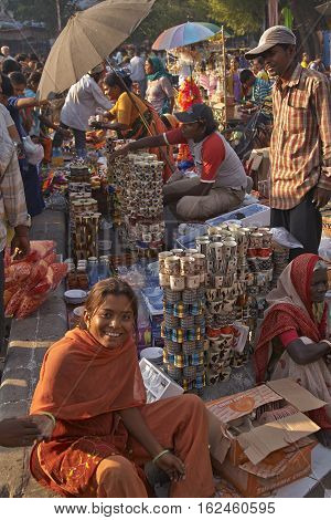 AHMADABAD, INDIA - OCTOBER 31, 2007: Woman in colourful sari selling crockery at a street market in the city of Ahmadabad, Gujarat, India