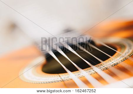 Acoustic guitar bridge and strings close up - macro - very shallow depth of field