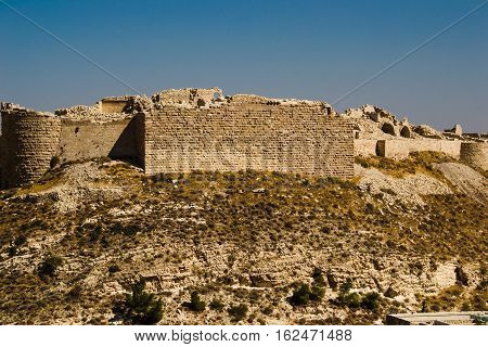 Photo of the Remains ancient impressive castle on mountain. Shobak crusader fortress. Castle walls. Travel concept. Jordan architecture and attraction