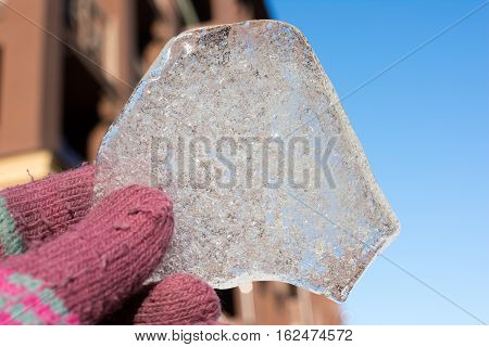 a piece of ice on a background of blue sky, unusually shaped piece of ice