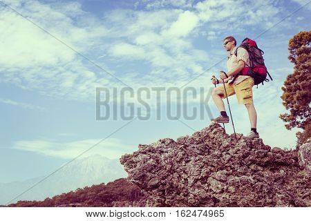 Summer hiking in the mountains with a backpack .