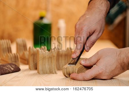 Carpenter hands cutting wood with chisel closeup