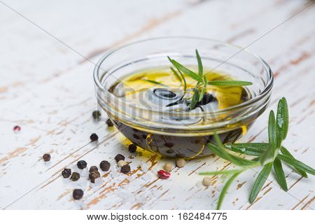 Olive oil with maslines on wood background, copy space