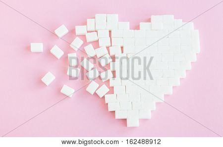 Broken heart made of sugar cubes. Rupture of relations. Sugar kills