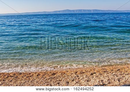 Beautiful sunshine on the clear blue sea, Tucepi town beach in Croatia Europe.