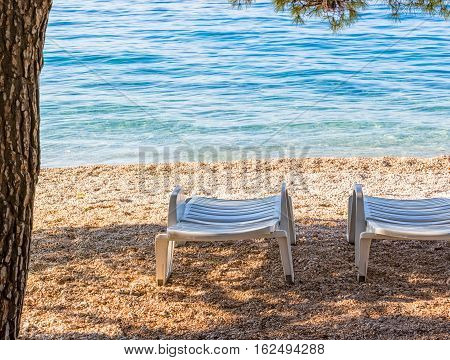 Deck chairs on the beach in Tucepi Croatia.