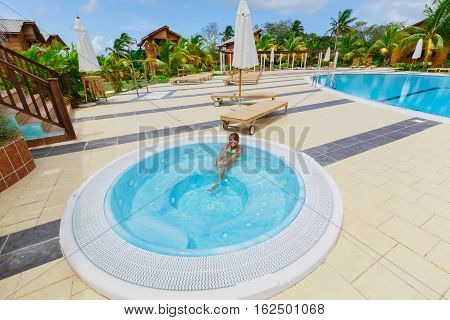 Cayo Guillermo island, Sercotel club resort, Cuba, July 4, 2016, nice amazing gorgeous view of hotel grounds with happy smiling little girl relaxing in Jacuzzi on sunny day
