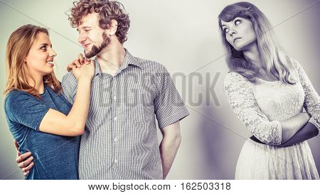 Jealousy and betrayal concept. Abandoned jelous girl watching on happy hugging couple. Triangle relationship.