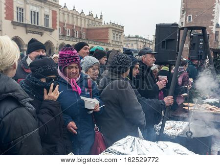 CRACOW POLAND - DECEMBER 18 2016: Christmas Eve for poor and homeless on the Central Market in Cracow. Every year the group Kosciuszko prepares the greatest eve in the open air in Poland