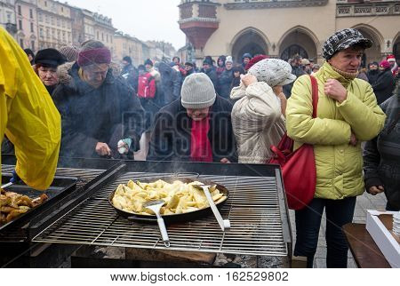 CRACOW POLAND - DECEMBER 18 2016: Christmas Eve for poor and homeless on the Central Market in Cracow. Every year the group Kosciuszko prepares the greatest eve in the open air in Poland